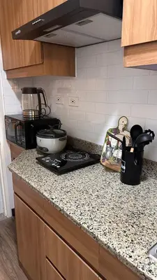 a kitchen with a counter top with a stove at The Framehaus with Free Parking at Sonora Garden Residences, Las Pinas in Manila