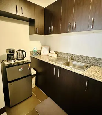 a small kitchen with a sink and a refrigerator at Staycation in Manhattan by House of Mereu in Manila