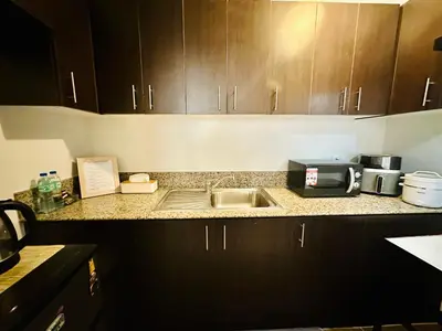 a kitchen counter with a sink and a microwave at Staycation in Manhattan by House of Mereu in Manila