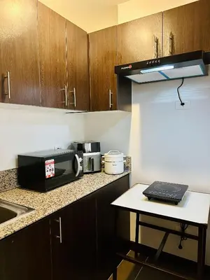 a kitchen with a counter with a microwave and a table at Staycation in Manhattan by House of Mereu in Manila