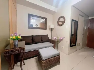 a living room with a couch and a table at Pasay Moa Stay at Shell Residences in Manila