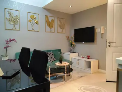 a living room with a couch and a tv at Beach Bliss Your 2 BR Condo Retreat Awaits in Manila