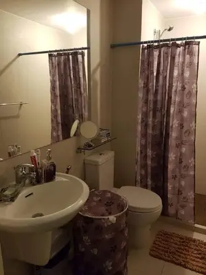a bathroom with a sink and a toilet and a mirror at Beach Bliss Your 2 BR Condo Retreat Awaits in Manila