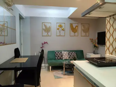 a kitchen and a living room with a green couch at Beach Bliss Your 2 BR Condo Retreat Awaits in Manila