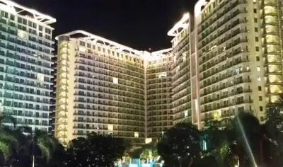 a large building with lights on it at night at Beach Bliss Your 2 BR Condo Retreat Awaits in Manila