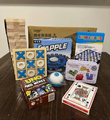 a table topped with a bunch of games and boxes at The Luxe Nook Shore Residences MOA in Manila