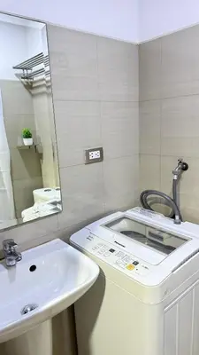 a bathroom with a sink and a mirror at The Luxe Nook Shore Residences MOA in Manila