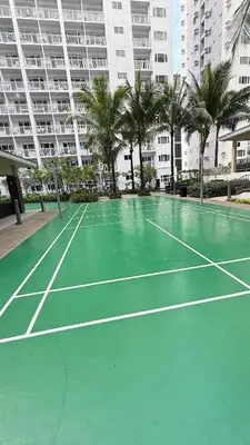 a tennis court in front of a large building at The Luxe Nook Shore Residences MOA in Manila
