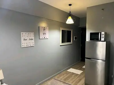 a kitchen with a refrigerator and a microwave at Vacation in Tribecca Towers in Manila