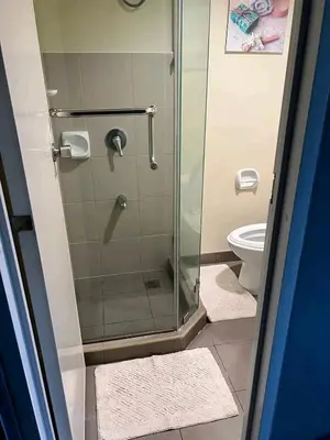 a bathroom with a shower and a toilet at Vacation in Tribecca Towers in Manila