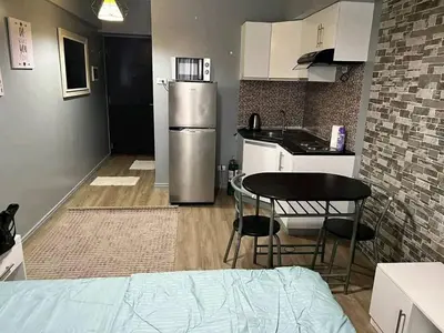 a small kitchen with a table and a refrigerator at Vacation in Tribecca Towers in Manila