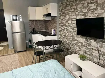 a kitchen with a small table and a kitchen with a refrigerator at Vacation in Tribecca Towers in Manila
