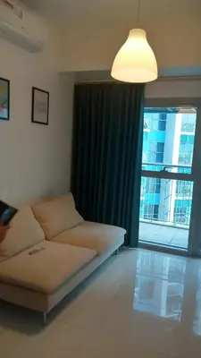 a living room with a couch and a large window at Charmimg 1 BR with Natural Light in Manila