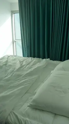 a white bed in a bedroom with a window at Charmimg 1 BR with Natural Light in Manila