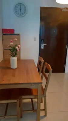 a table and chairs with a vase with flowers on it at Charmimg 1 BR with Natural Light in Manila