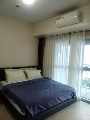 a bedroom with a bed and a window with a air conditioner at Cozy Retreat 3 BR unit The Bayshore in Manila