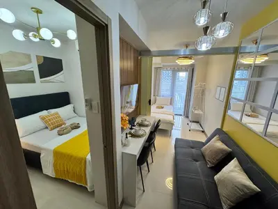 a bedroom with a bed and a table and a couch at S Residences Family Room 512 by Prime Stay MOA in Manila