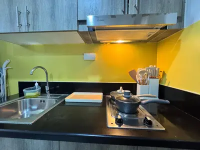 a kitchen with a sink and a pot on a stove at S Residences Family Room 512 by Prime Stay MOA in Manila
