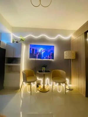 a living room with a table and chairs and a tv at H&M staycation Shore 2 tower 2 in Manila