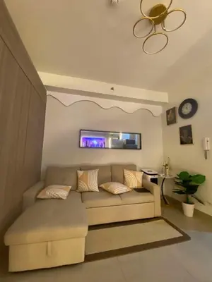 a living room with a couch and a window at H&M staycation Shore 2 tower 2 in Manila