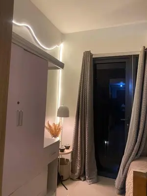 a bedroom with a bed and a window and a lamp at H&M staycation Shore 2 tower 2 in Manila