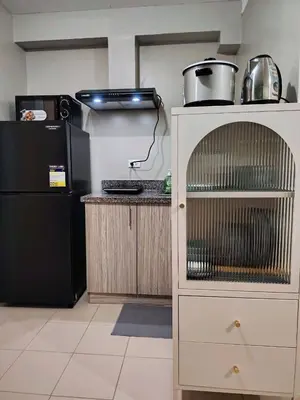 a kitchen with a black refrigerator and a counter with a shelf at Coco Home in Manila