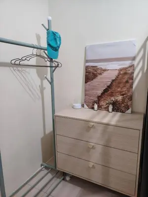 a dresser with a picture on top of it at Coco Home in Manila