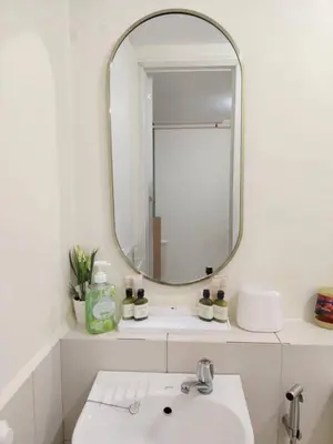a bathroom with a mirror and a sink at Coco Home in Manila