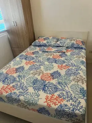 a bed in a bedroom with a blue and orange bedspread at Hotel Essence Service Road in Manila
