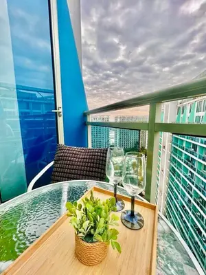 a table with two glasses and a plant on a balcony at Hotel Essence Service Road in Manila