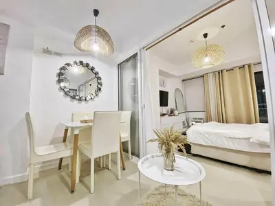 a room with a dining table and a bedroom at Hotel Essence Service Road in Manila