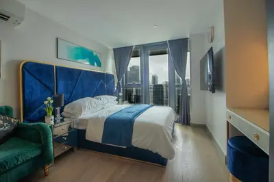 a bedroom with a bed and a couch and a window at Century Spire Condominium, Makati City in Manila