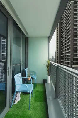 a balcony with chairs and a table and grass at Century Spire Condominium, Makati City in Manila