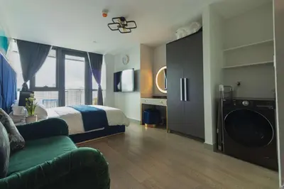 a bedroom with a bed and a washing machine at Century Spire Condominium, Makati City in Manila