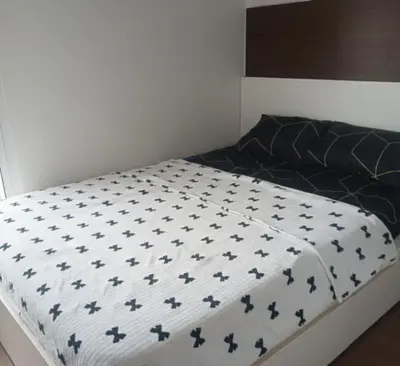 a bed with a black and white comforter on it at air residences in Manila