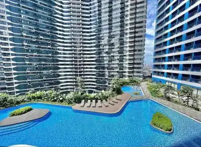an aerial view of a large building with a swimming pool at air residences in Manila