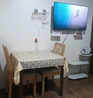 a table with two chairs and a television on a wall at air residences in Manila