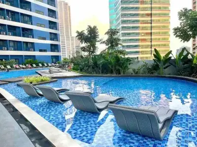 a swimming pool with lounge chairs in a building at air residences in Manila
