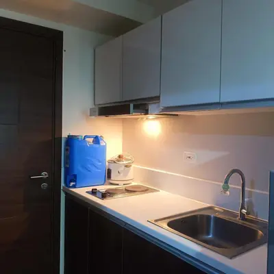 a kitchen with a sink and a blue box on the counter at air residences in Manila