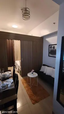 a living room with a bed and a table at Shore Residences Pasay in Manila