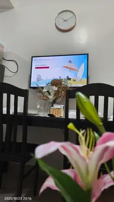 a desk with a television and a table with a plant at Shore Residences Pasay in Manila