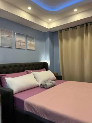 a bedroom with a large bed with pink and white sheets at Azure Urban Resort by Cozy Haven in Manila