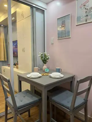 a table and two chairs with plates and flowers on it at Azure Urban Resort by Cozy Haven in Manila