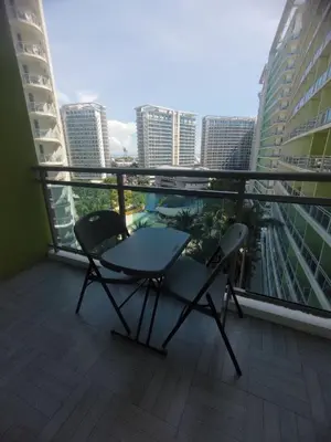 a balcony with two chairs and a table on a balcony at Azure Urban Resort by Cozy Haven in Manila