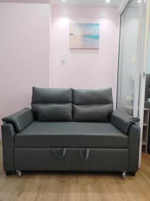 a couch in a living room with a painting on the wall at Azure Urban Resort by Cozy Haven in Manila
