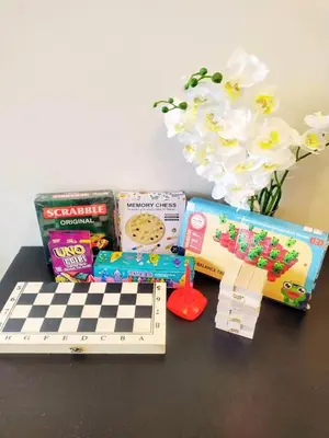 a table with a chess board and other toys and flowers at Pasay FL Staycation in Manila