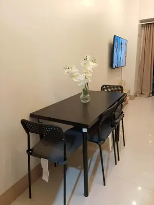 a black dining room table with chairs and a vase of flowers at Pasay FL Staycation in Manila