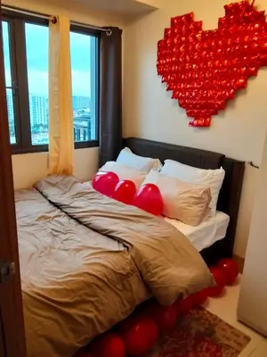 a bedroom with a bed with red hearts on the wall at Pasay FL Staycation in Manila