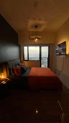 a bedroom with a bed with a large window at Air Residences Minimal Style Unit w Balcony - Near Trident Tower and Salcedo in Manila