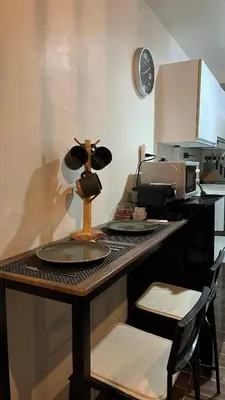 a kitchen with a counter with a table with plates and a microwave at Air Residences Minimal Style Unit w Balcony - Near Trident Tower and Salcedo in Manila